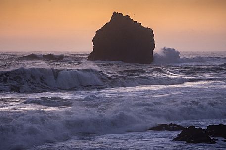 Lonely rock formation in the sea near the cliff of Valahnkur, Reykjanes peninsula, Iceland